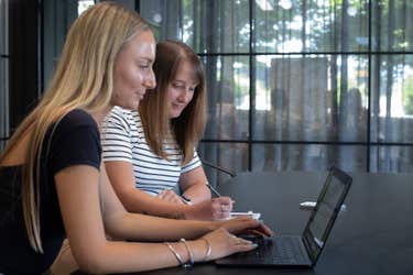 Two Blackpepper team members discuss project details in a meeting room